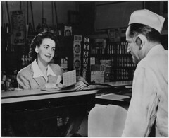 A Customer Can Use the Ration Books of the Whole Family. But the First Thing She Will Want to Know When She Buys Pork Chops, Pound of Butter or a Half Pound of Cheese Is - "How Many Points Will It Take?" 1941 - 1945