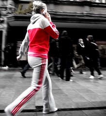 Women in track suit walking while talking on a mobile phone