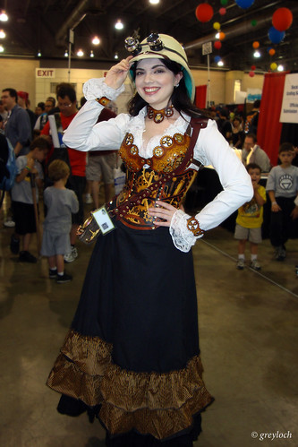 A woman in steampunk outfit, including bushy skirts and an old hat