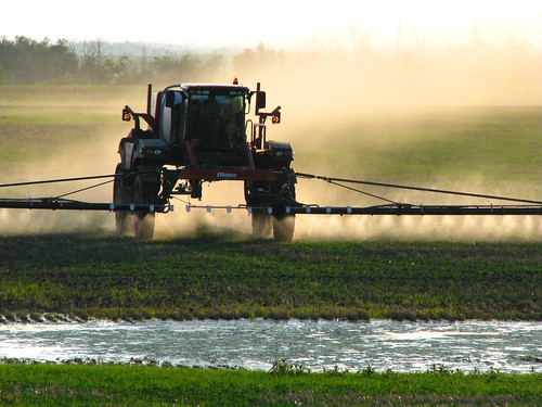 Spraying crops in the evening dusk