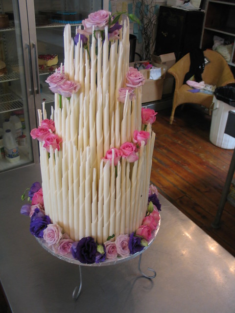 White chocolate cigars wedding cake with lilac pink purple flowers