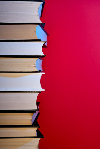 Stack of hardcover encyclopedias against red background