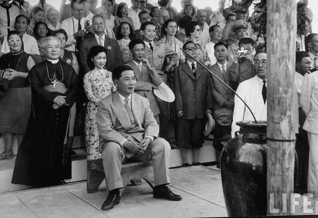 1957 - Vietnamese President Ngo Dinh Diem (seated) and his brother Bishop Ngo Dinh Thuc (L) attending a program held during New Year celebration in the central highlands.