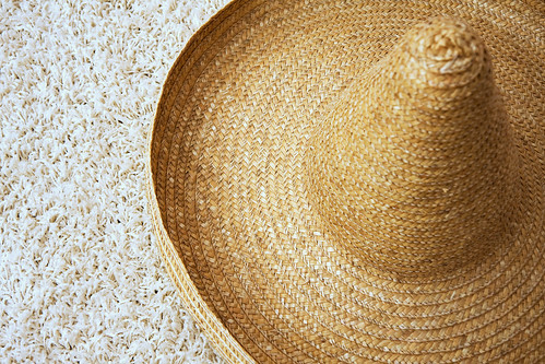 Large straw sombrero with twisted tip on carpet