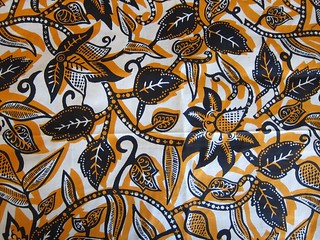 African print cotton: Orange and blue leaves and vines.