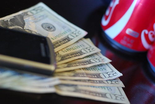 Money, cell phone and soda