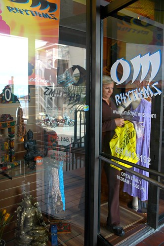 Random shopping, woman leaving with a purchase, OM Rhythms, Monterey, California, USA by Wonderlane
