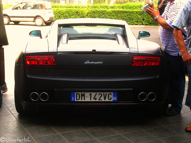 A stunning Lamborghini Gallardo with a matte black paintjob parked in front