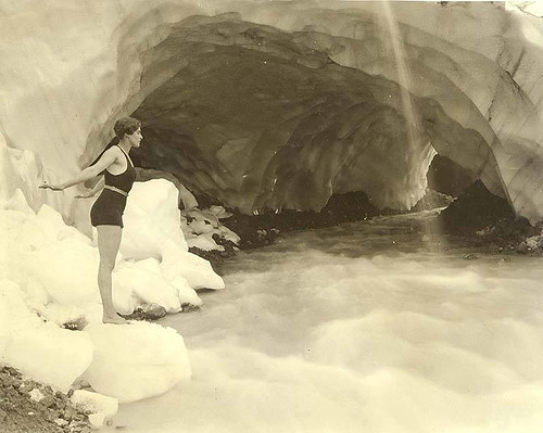 Woman in bathing suit at edge of stream near Paradise Glacier ice cave, Mount Rainier National Park