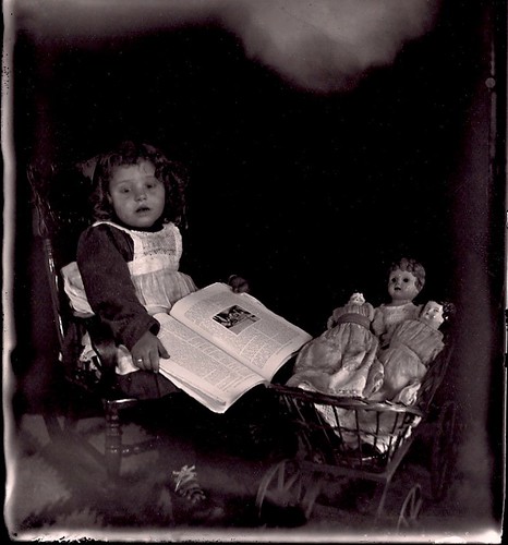 Little girl with book and dolls by sctatepdx