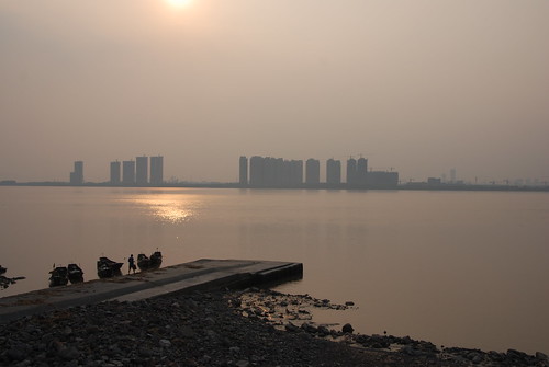 錢塘江畔蕭山農村的夕陽VS遠方的杭州市區都市高樓