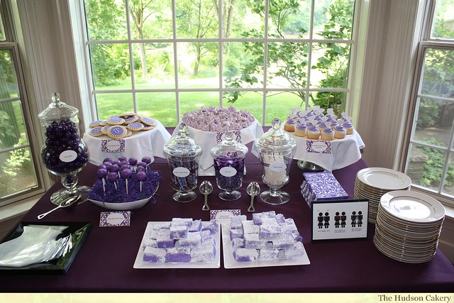 The purple and white dessert buffet includes cake pops 