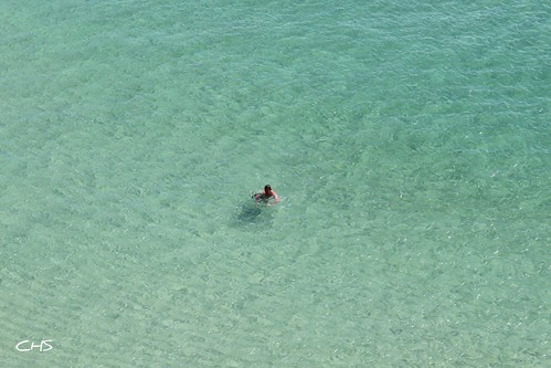 Carribbean? Nah, Cornwall at it's finest!  A lone swimmer swims the crystal blue waters off Porthcurno beach, West Cornwall by Stocker Images