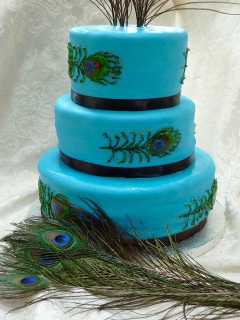 Peacock themed wedding cake covered in fondant and hand painted peacock 