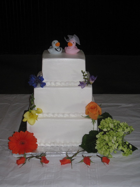 This wedding cake features two rubber ducks as a topper and beautiful wild