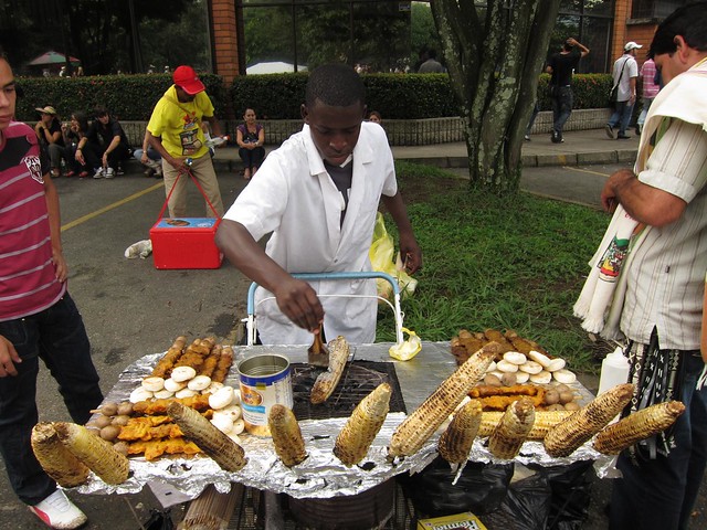 A street vendor cooks up corn on the cob, a popular snack food.