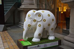 statue from London Elephant Parade, white baby elephant with gold currency symbol spots