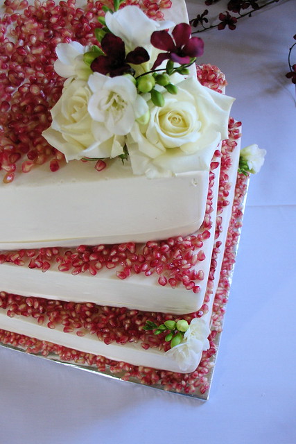 Red Velvet wedding cake decorated with pomegranate and white roses