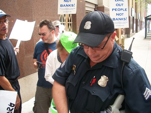 Detroit cop seizes the bullhorn used by the Moratorium NOW! Coalition outside Bank of America during a demonstration calling for a freeze on all foreclosures and evictions. The demonstration took place on September 1, 2010. (Photo: Abayomi Azikiwe) by Pan-African News Wire File Photos