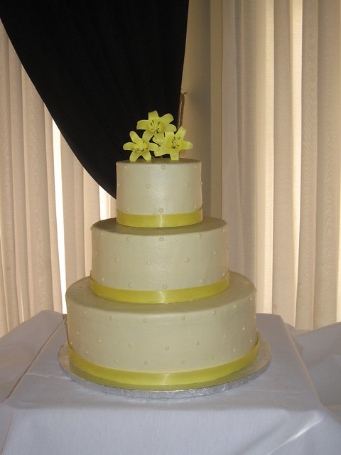 A 3tier round wedding cake with ribbon along the base and icing beading 