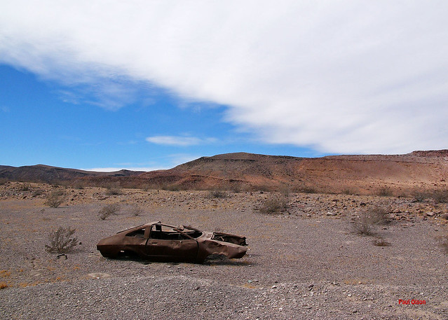 Old rusty car in desert landscape