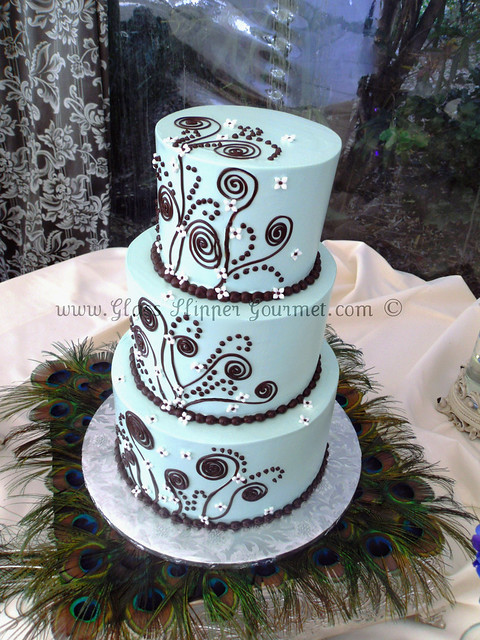 Bright aqua blue buttercream with dainty white cutout flowers and dark 