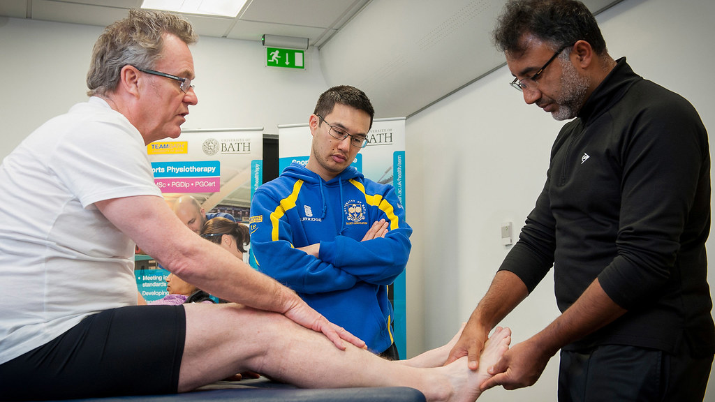 Medical staff examine a sports injury watched by a student