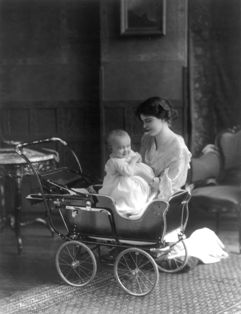 Woman and infant posed with a baby carriage, 1913