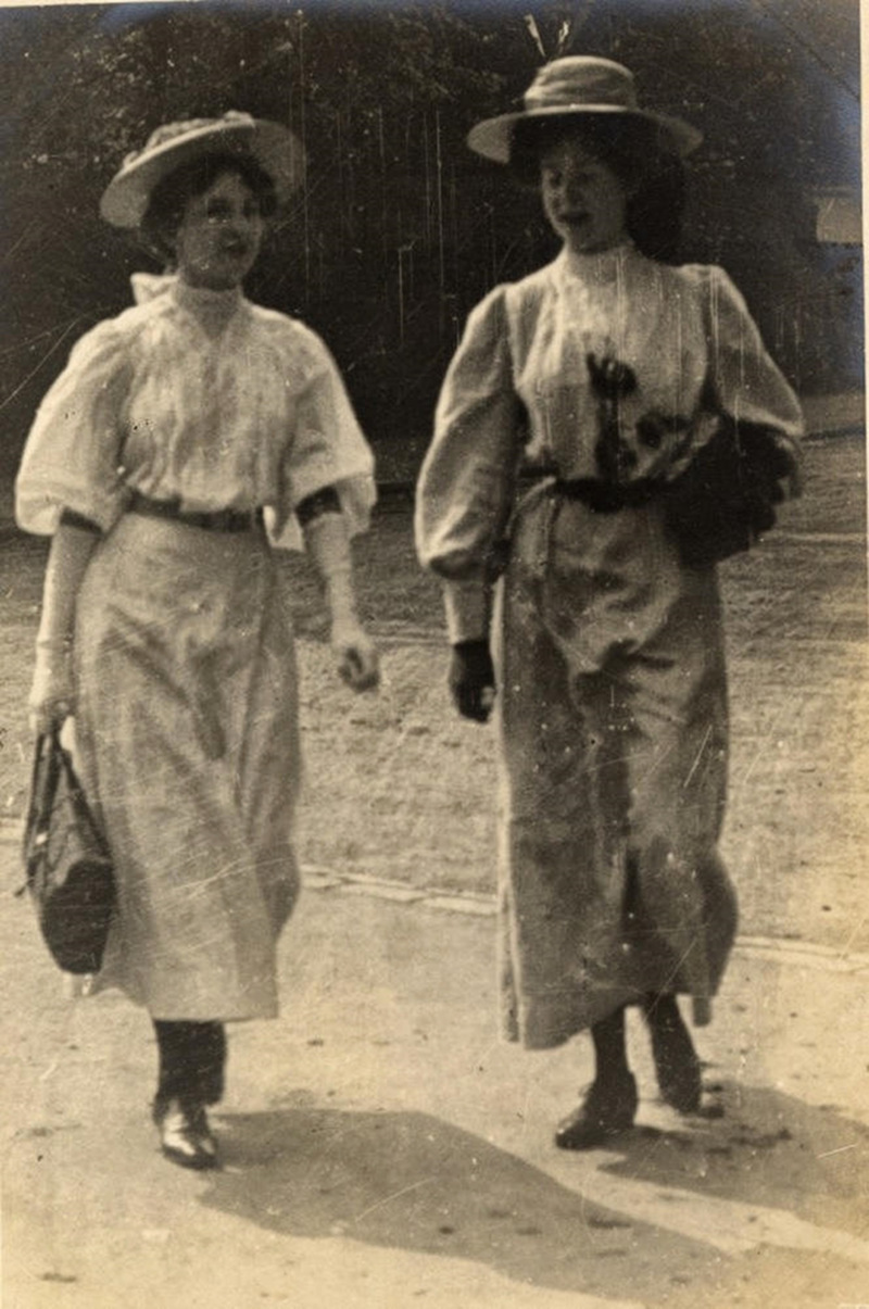 Two women engaged in conversation as they walk, 1908
