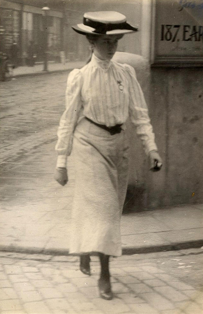A young woman in Cromwell Road, London on July 12, 1905 in a stylish striped shirt with a belt and an ankle-length skirt