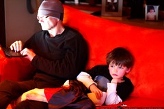 nick watching coraline with his feet in grandpa's la… 