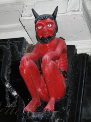 Devil statue by shop signage, York