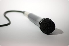 A corded hand-held microphone laid on a surface
