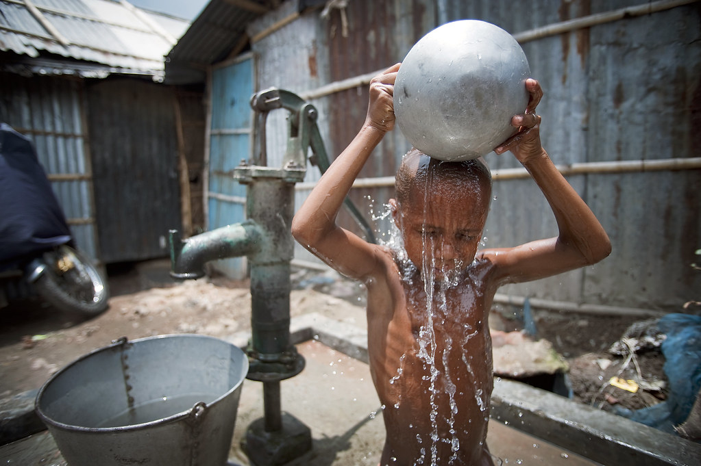 孟加拉達卡一處貧民窟，孩童正用抽地下水來盥洗。(Source: UN Photo/Kibae Park via Flckr)