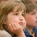 third grade student listening intently to assembly speaker