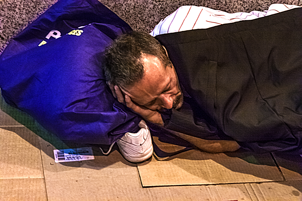 Man-using-bag-and-shoe-as-pillow--Center-City