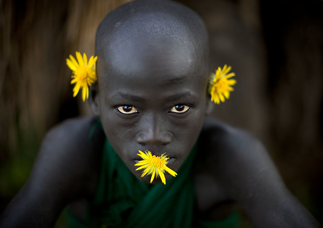 Surma boy with yellow flowers - Tulgit Omo Ethiopia - Tribes of the World