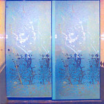 Puerta de ducha con aluminio pintado en azul y aplicación de arenado a figuras