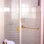 Puerta de ducha con accesorios pintados en color dorado