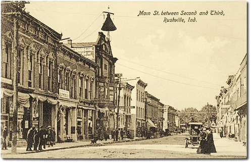 horses people woman usa signs man men history cars sepia buildings walking advertising awning clothing women indiana streetscene transportation drugs shops pedestrians storefronts buggy buggies automobiles businesses rushville rushcounty hoosierrecollections