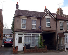 An end-of-terrace two-storey house with an alleyway on one side and access through to the back of the terrace on the other.
