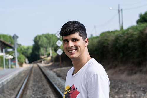 oneperson nikon d3300 nikond3300 50mm realpeople casualclothing outdoors focusonforeground transportation youngadult portrait lifestyles frontview leisureactivity day railtransportation railroadtrack standing youngmen tree headshot smiling sky people