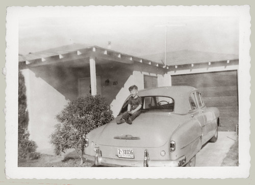 Boy sitting on a car trunk