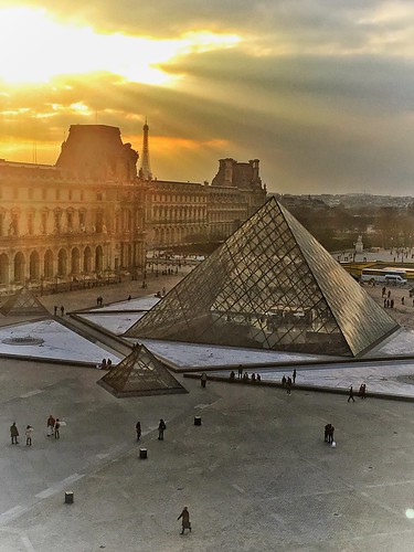 the louvre museum historic monument building architecture pyramid glass triangle chinese american i m pei architect courtyard clouds sky city paris france landmark history largest onasill seine river mustsee travel tourist french central sun rays sunset