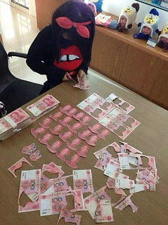 Kid cutting up Chinese banknotes