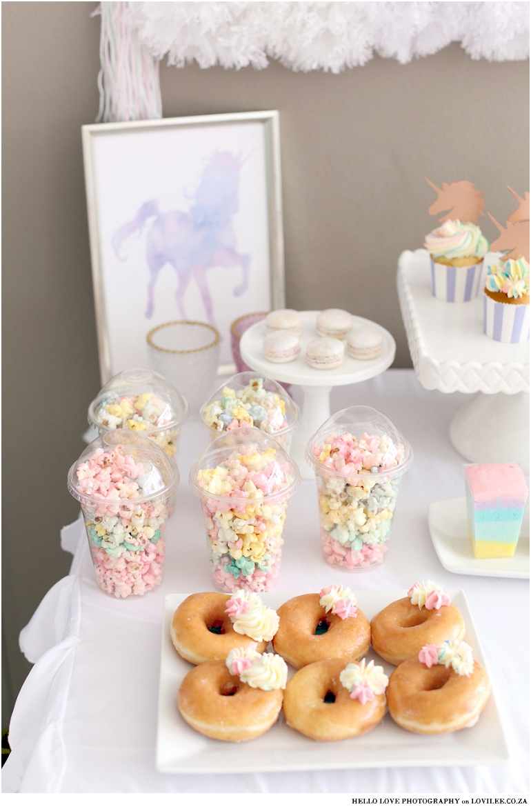 Unicorn party decor - Candy table with rainbow popcorn and doughnuts