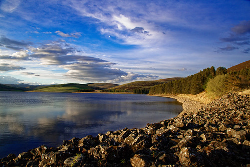calm reservoir backwater freshwater scotland scottishwater scenery sunlight relaxing shoreline rock firs hills mountains clouds canon 5d irons atomspheric reflections landscape ecosse heathland water