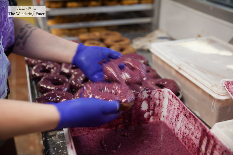 Dunking the doughnuts into the housemade blueberry glaze