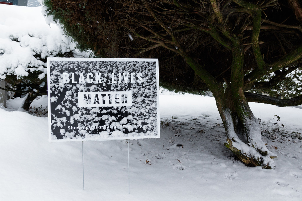 A Black Lives Matter sign is partly covered in snow