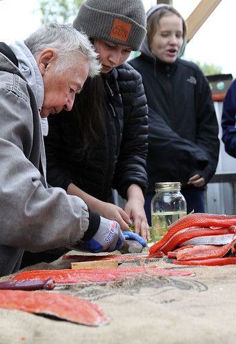 Mary Lou Bottorff shows young participants in a Yinihugheltani workshop in June how to strip and smoke salmon.